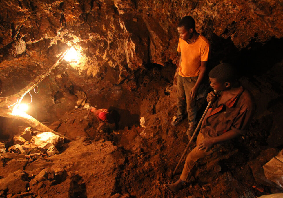 "Mwinilunga, Zambia - December 6th, 2012: Three young African miners work in an underground mine and dig for reseources."